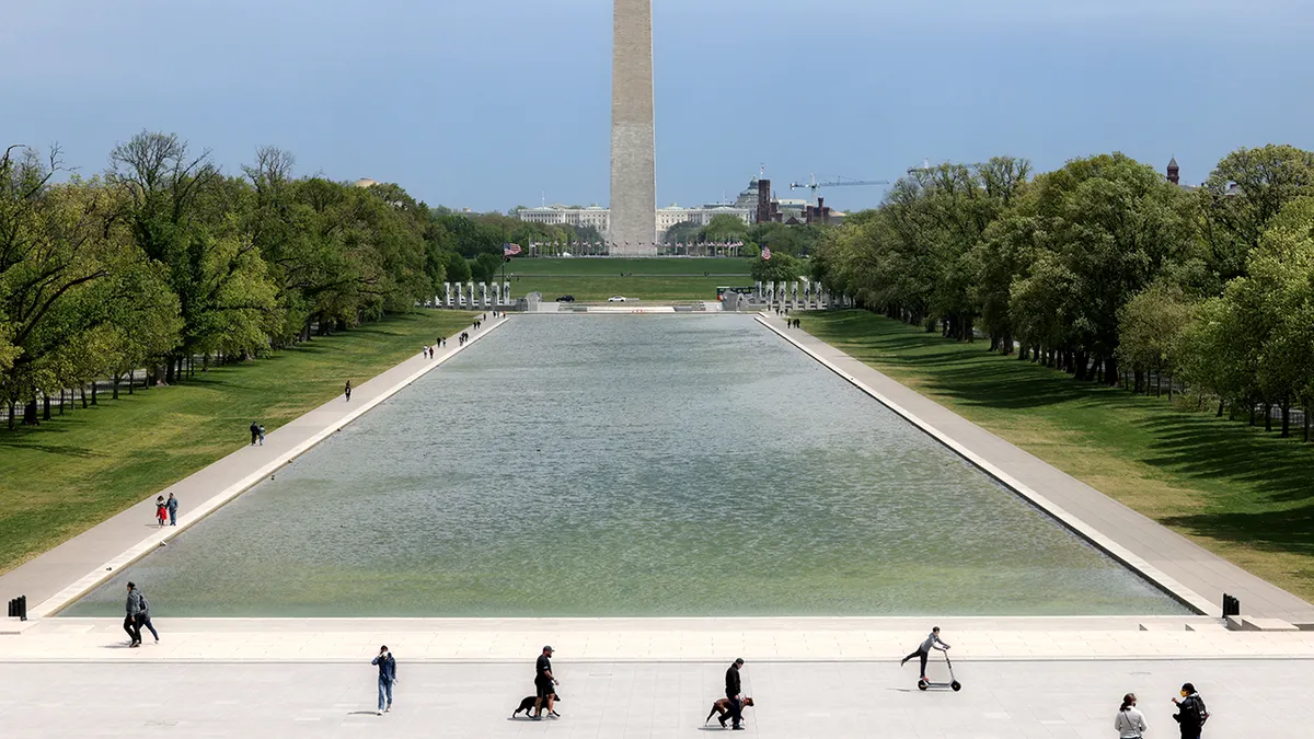 Ljudi uživaju na otvorenom ispred Lincoln Memorial Reflecting Pool s Washingtonovim spomenikom u pozadini