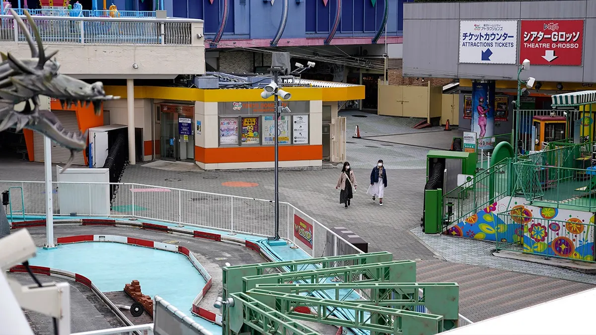 dvoje ljudi hoda praznim tematskim parkom