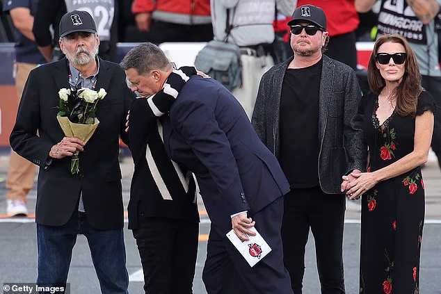 Gaye Busch u zagrljaju izvršnog direktora NASCAR-a Stevea O'Donnella tijekom odavanja počasti njezinom sinu