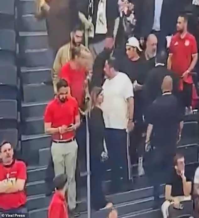 Video prikazuje Marinakisa, odjevenog u bijelu košulju, kako hoda niz VIP stepenice prije nego što se pogleda s Dimitriadisom i čini se da mu nešto šapće na uho