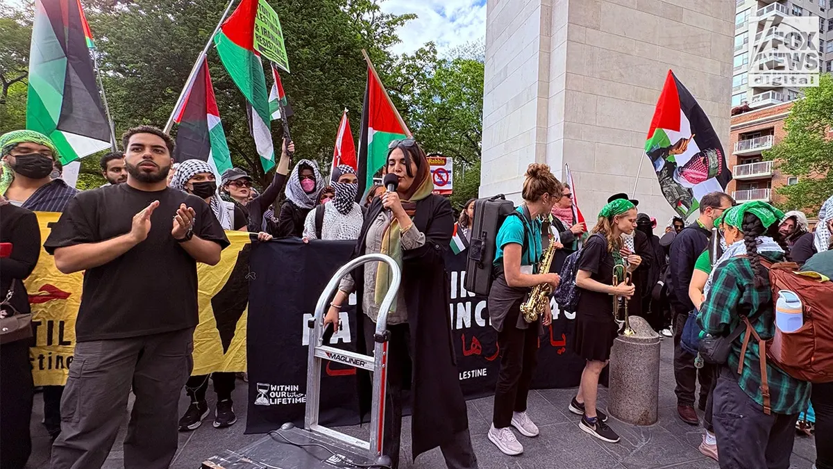 Nerdeen Kiswani govori protuizraelskim prosvjednicima u parku Washington Square okružen palestinskim zastavama i transparentima prosvjeda.
