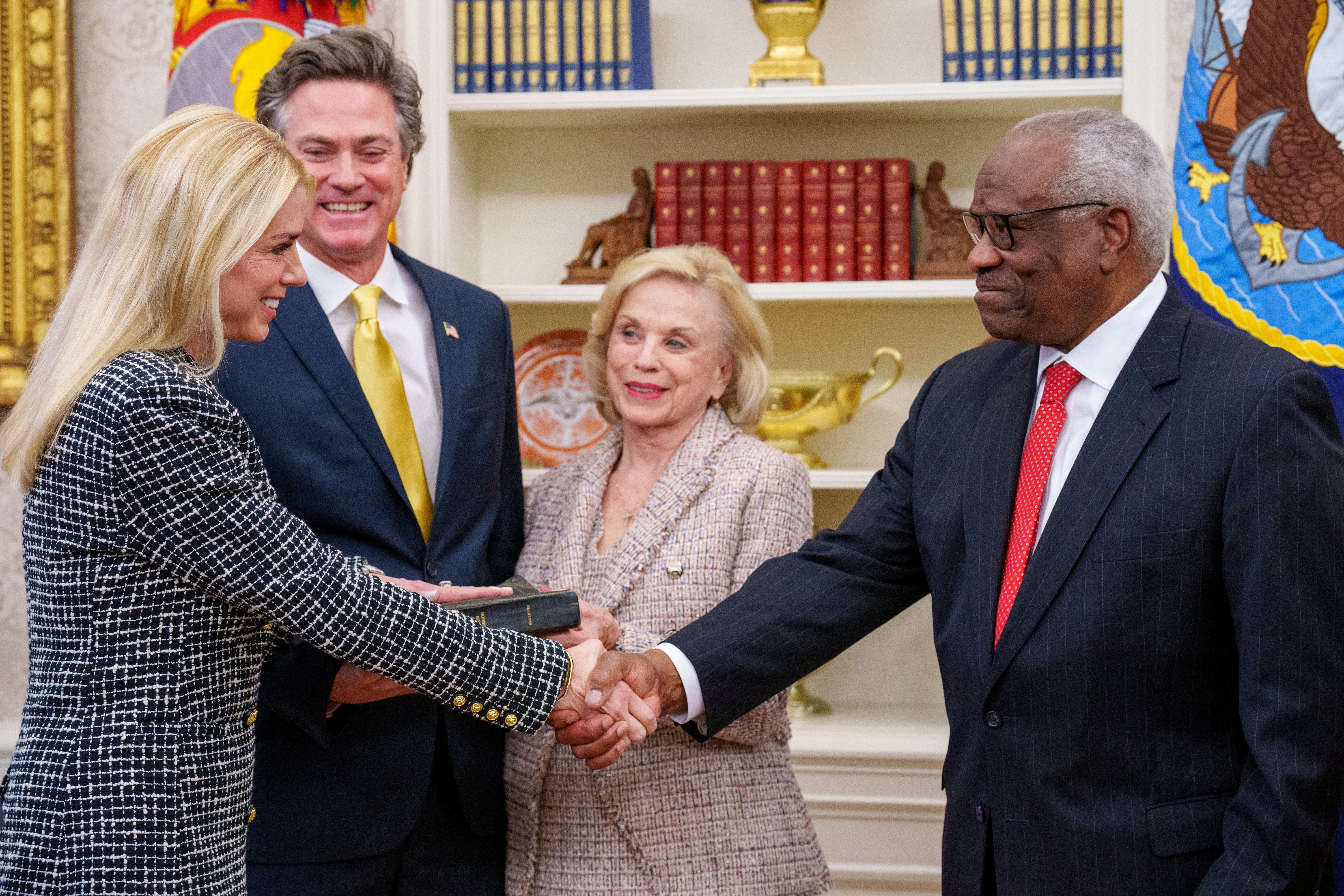 Sudac Vrhovnog suda SAD-a Clarence Thomas (desno), rukuje se s Pam Bondi (lijevo) nakon što je položila prisegu za državnu tužiteljicu SAD-a