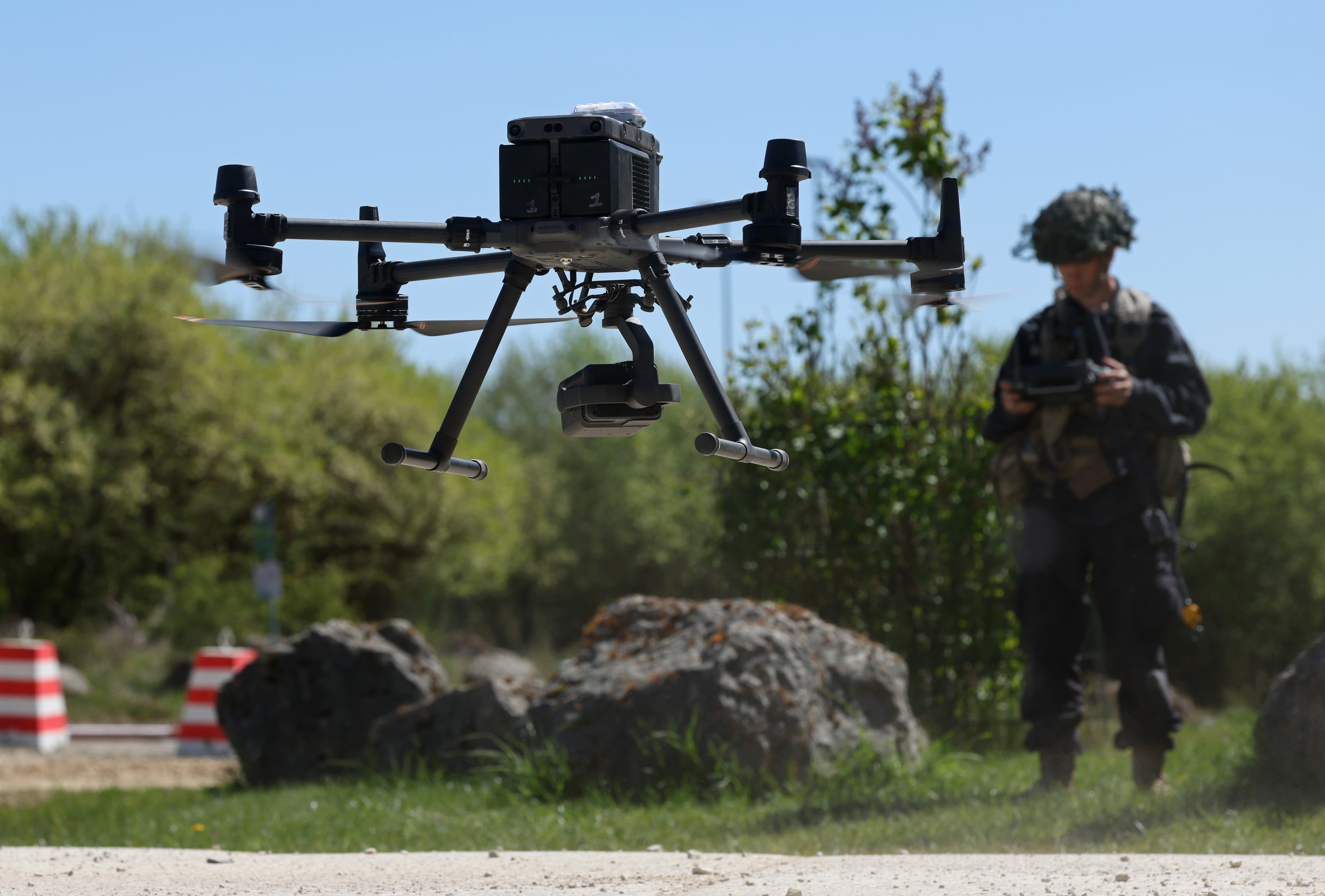 Član Zapovjedništva za obuku 7. kopnene vojske SAD-a, odjeven u crno u ulozi protivničke snage, upravlja dronom DJI Matrice tijekom vojne vježbe 'Combined Resolve' u 7. ATC Joint Multinational Readiness Center 30. travnja 2026. u Hohenfelsu, Njemačka