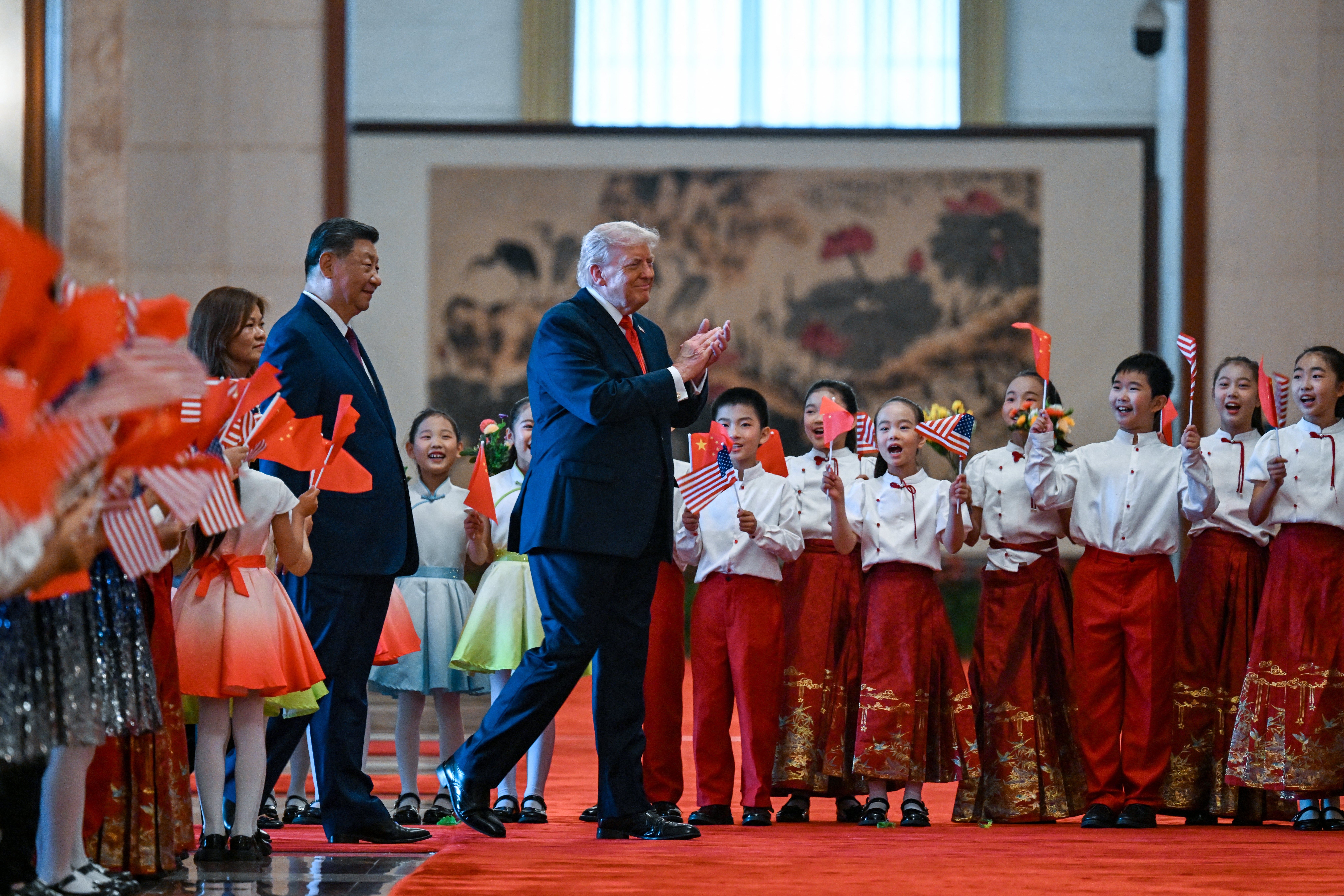Američki predsjednik Donald Trump (desno) i kineski predsjednik Xi Jinping (lijevo) pozdravljaju djecu mašući kineskim i američkim državnim zastavama i cvijećem tijekom ceremonije dobrodošlice u Velikoj dvorani naroda