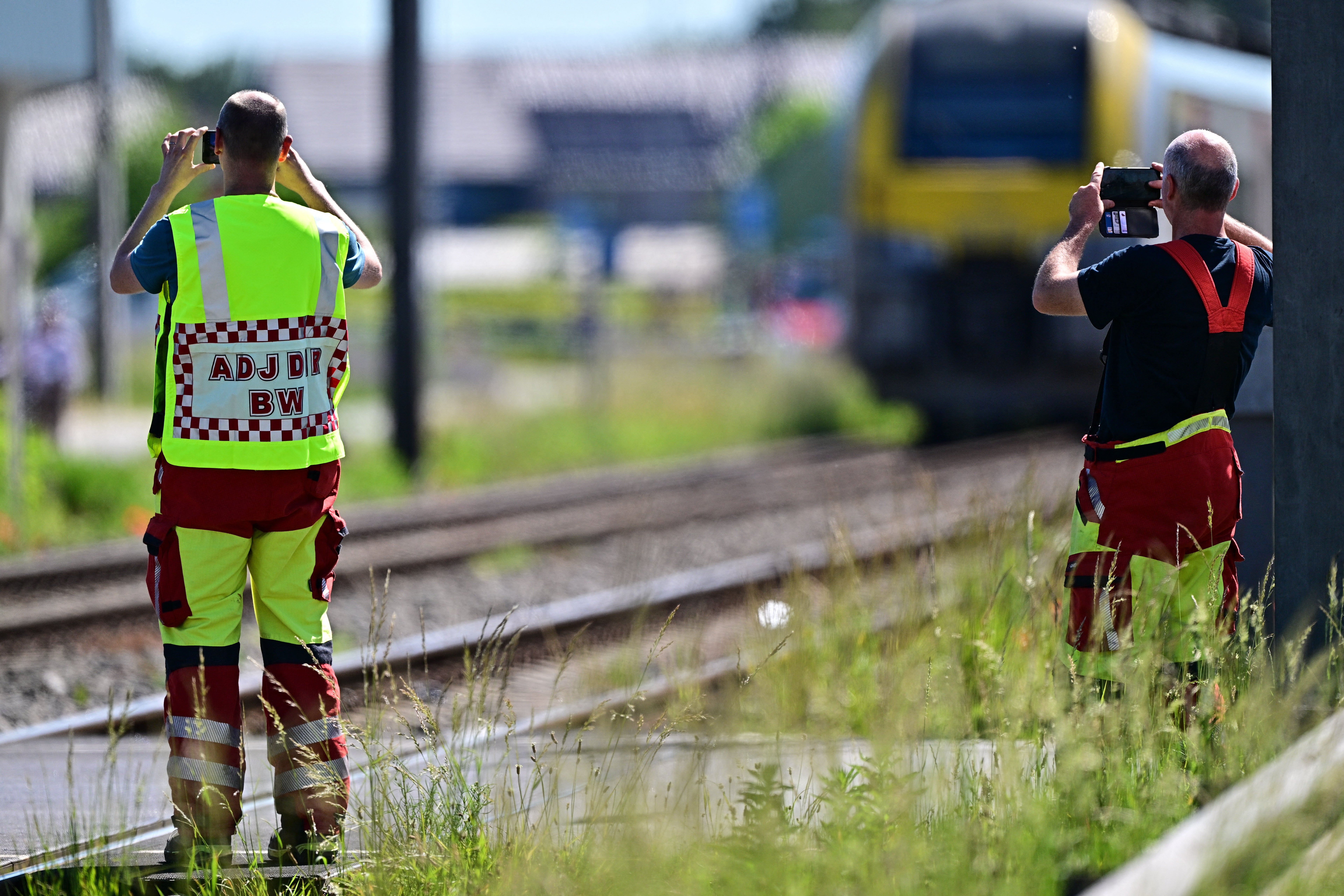 Hitne službe fotografiraju svojim pametnim telefonima mjesto nesreće nakon što je vlak udario u školski autobus, na željezničkom prijelazu Vierhuizen u Buggenhoutu