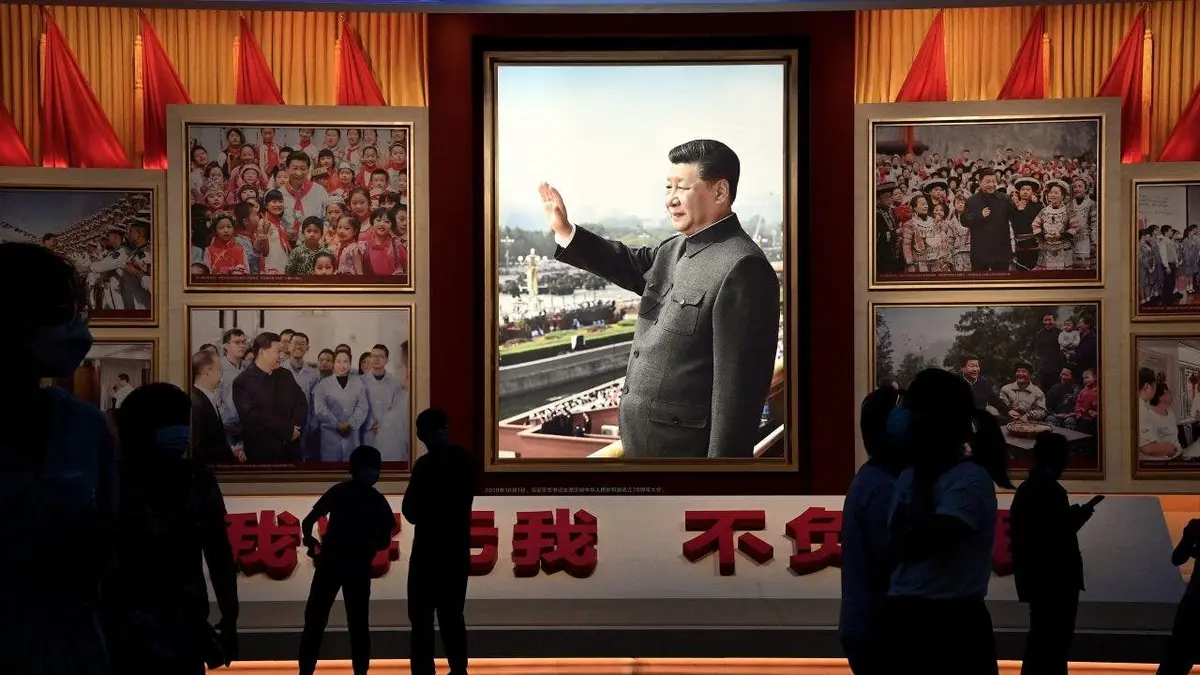 People standing in front of images of Chinese President Xi Jinping at a museum in Beijing