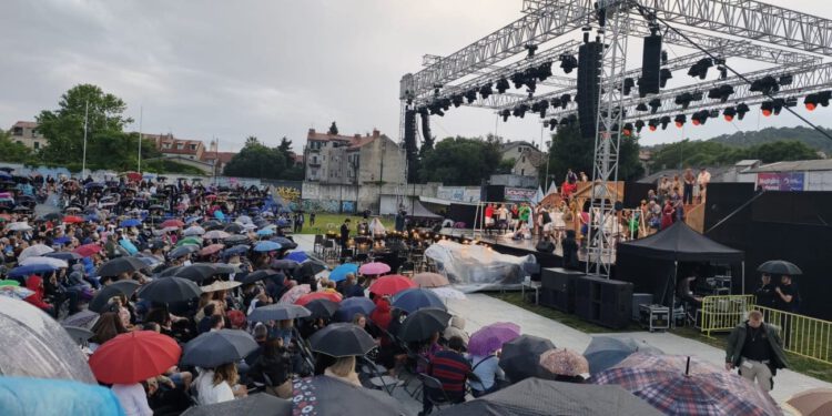 KIŠA NIJE RASTJERALA PUBLIKU “Kraljica lopte” izvodi se pred prepunim Starim placom, gledatelji pod kišobranima podržali ansambl