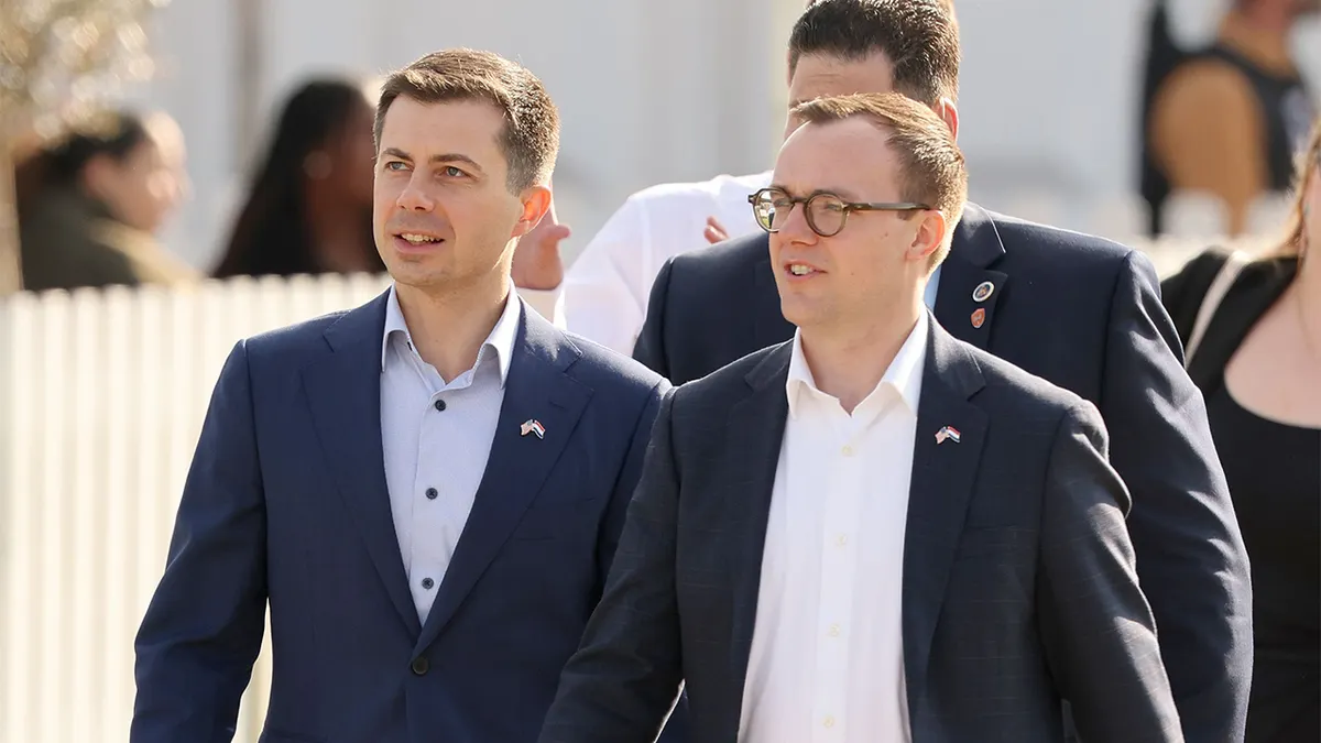 Ministar prometa Pete Buttigieg i suprug Chasten Buttigieg stoje na prijemu u Haagu