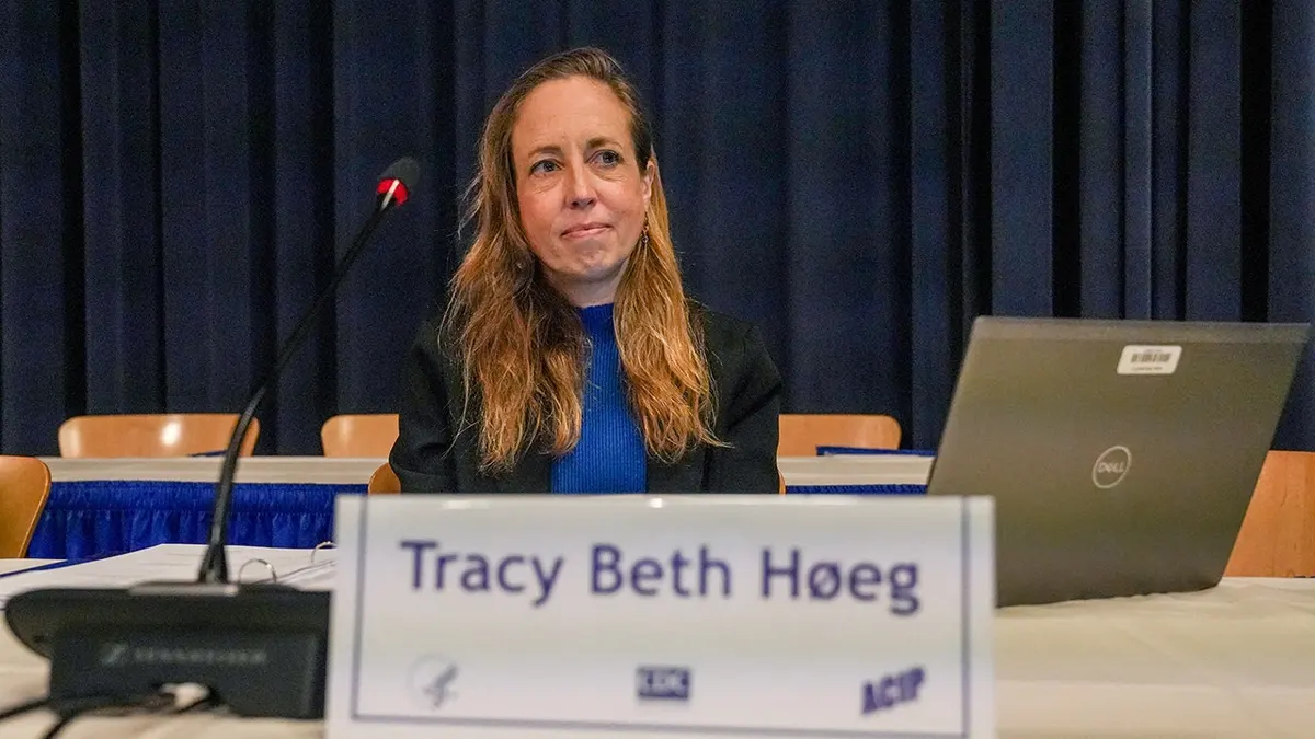 Dr. Tracy Beth Hoeg sjedi ispred kartice s njezinim imenom.