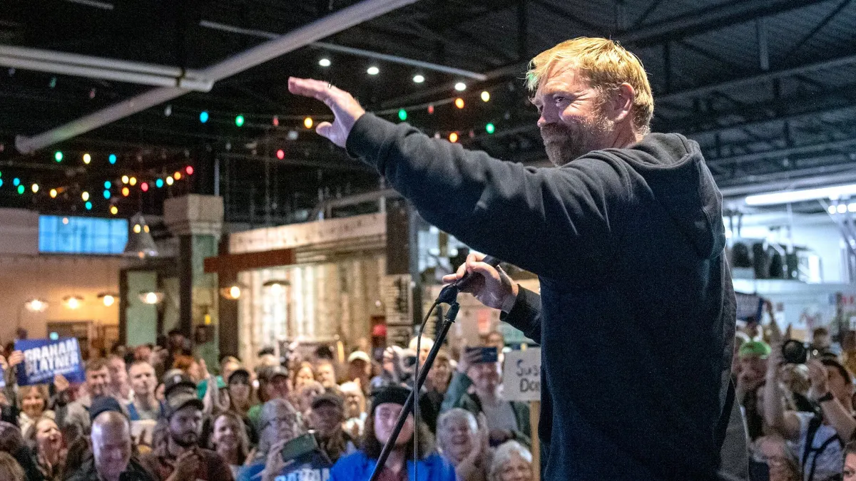 Graham Platner pozdravlja gužvu tijekom gradske vijećnice u Portlandu, Maine
