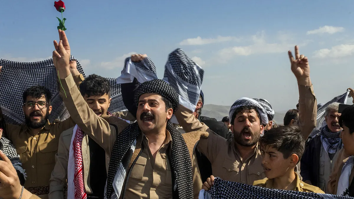 Muškarci i žene drže kurdske šalove i ruže tijekom svečanosti Nowruz u Saqqezu, Iran