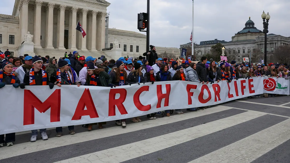 Prosvjednici protiv pobačaja drže transparent ispred zgrade Vrhovnog suda SAD-a u Washingtonu, DC