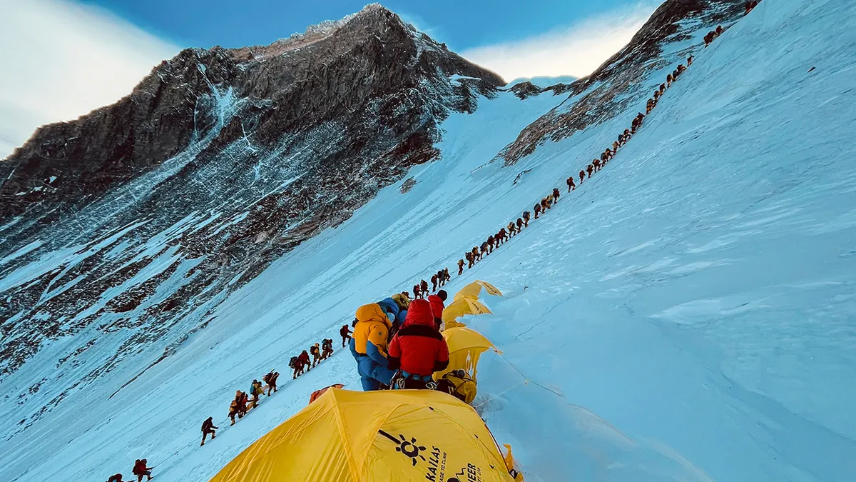 Planinari postrojeni penju se uz padinu na Mount Everestu.