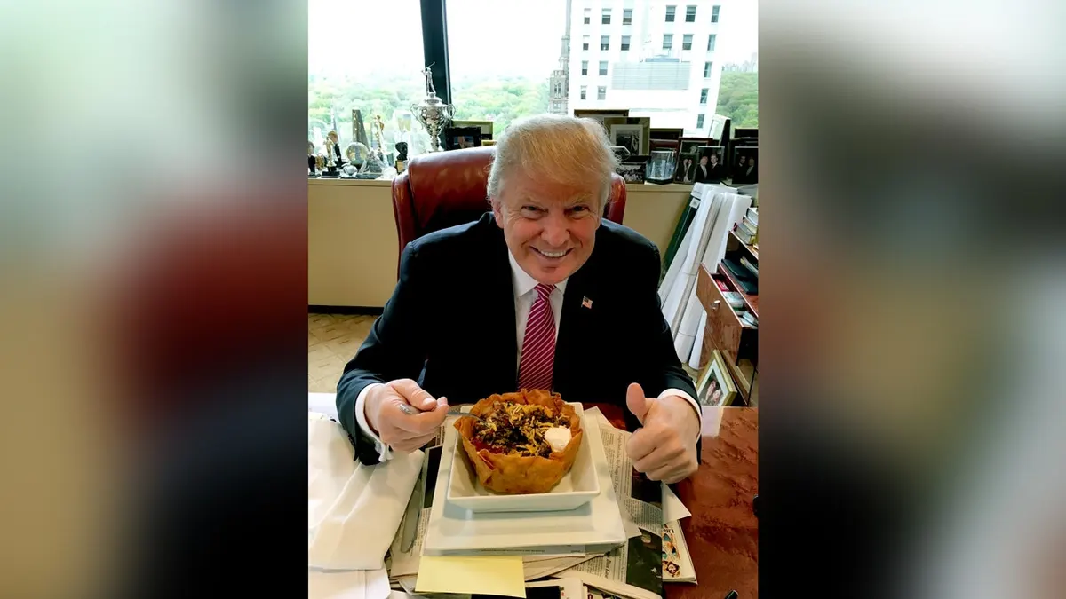 Trump se smiješi sa zdjelom za tacos i diže palac gore.