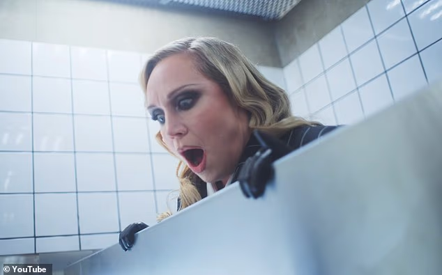 Drugi partijaner gleda preko vrha kabine u potpunom šoku što Madonna radi