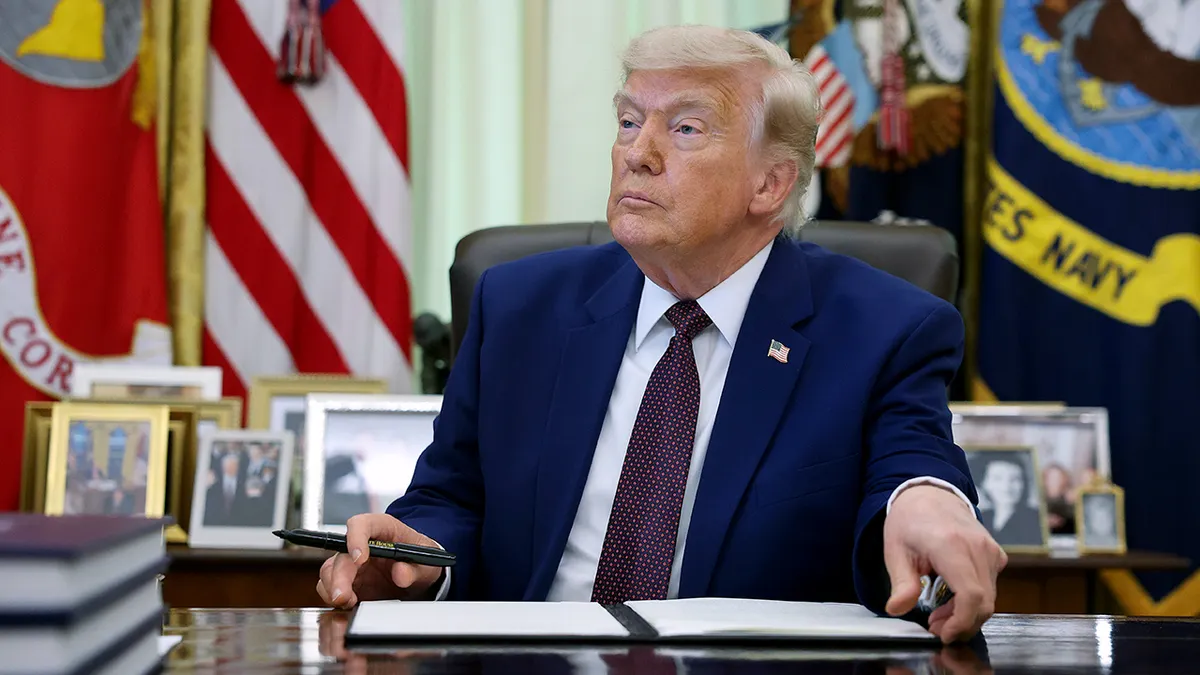 Predsjednik Donald Trump potpisuje izvršnu uredbu u Ovalnom uredu Bijele kuće.