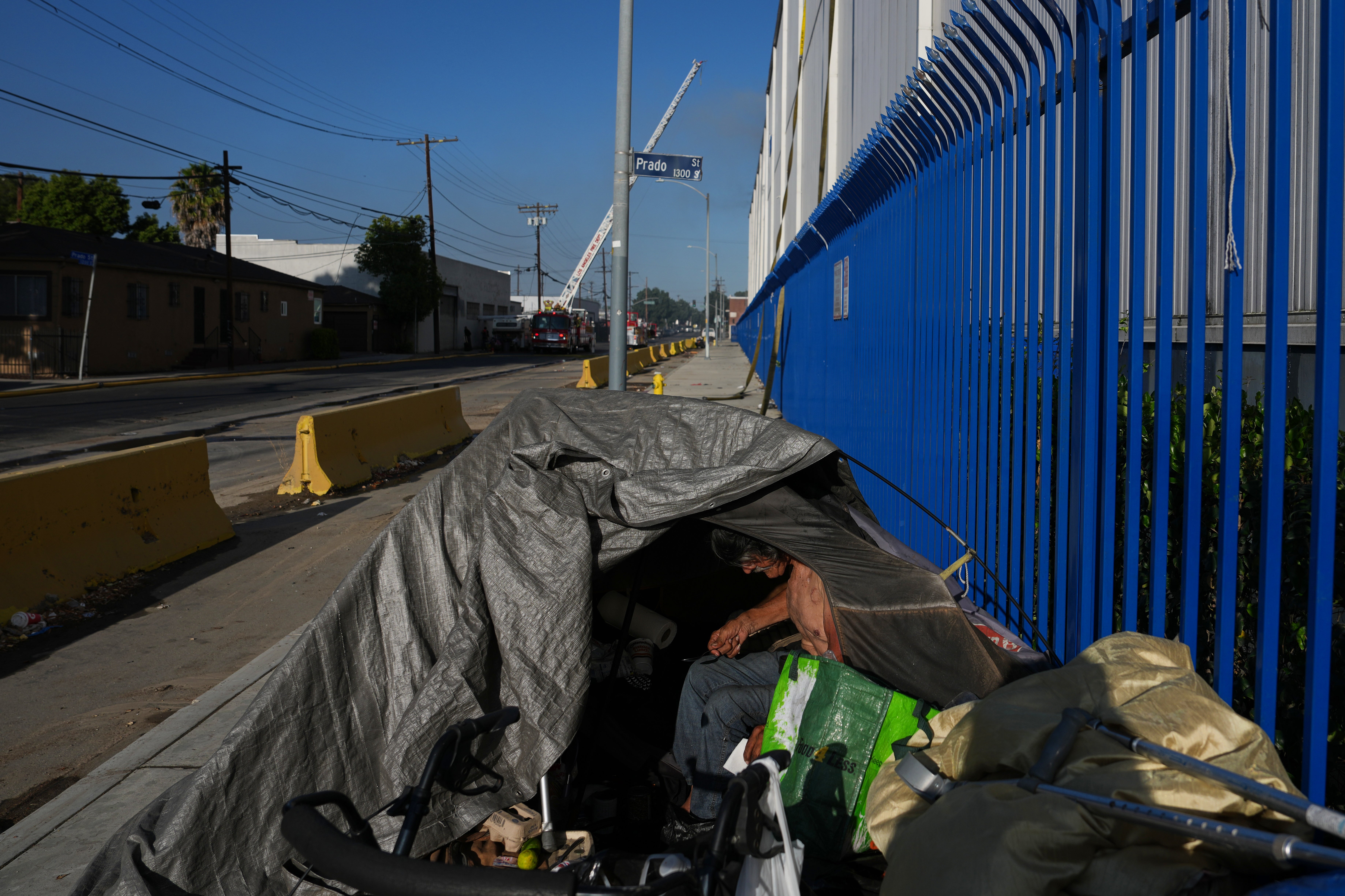 Beskućnik kampira blizu mjesta požara u skladištu u četvrti Boyle Heights u Los Angelesu
