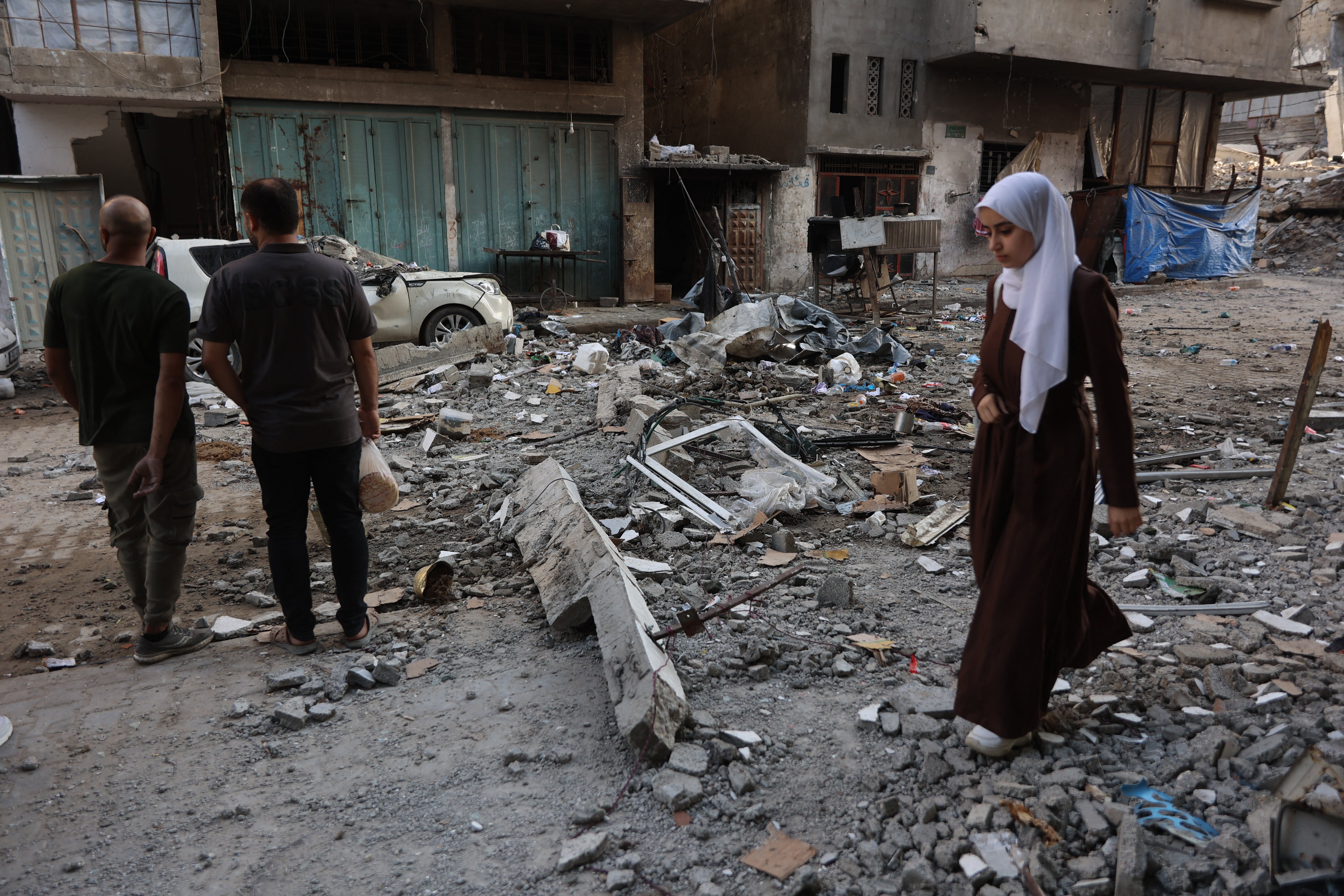 Palestinka hoda po olupinama stambenih zgrada koje su uništile izraelske snage u gradu Gazi