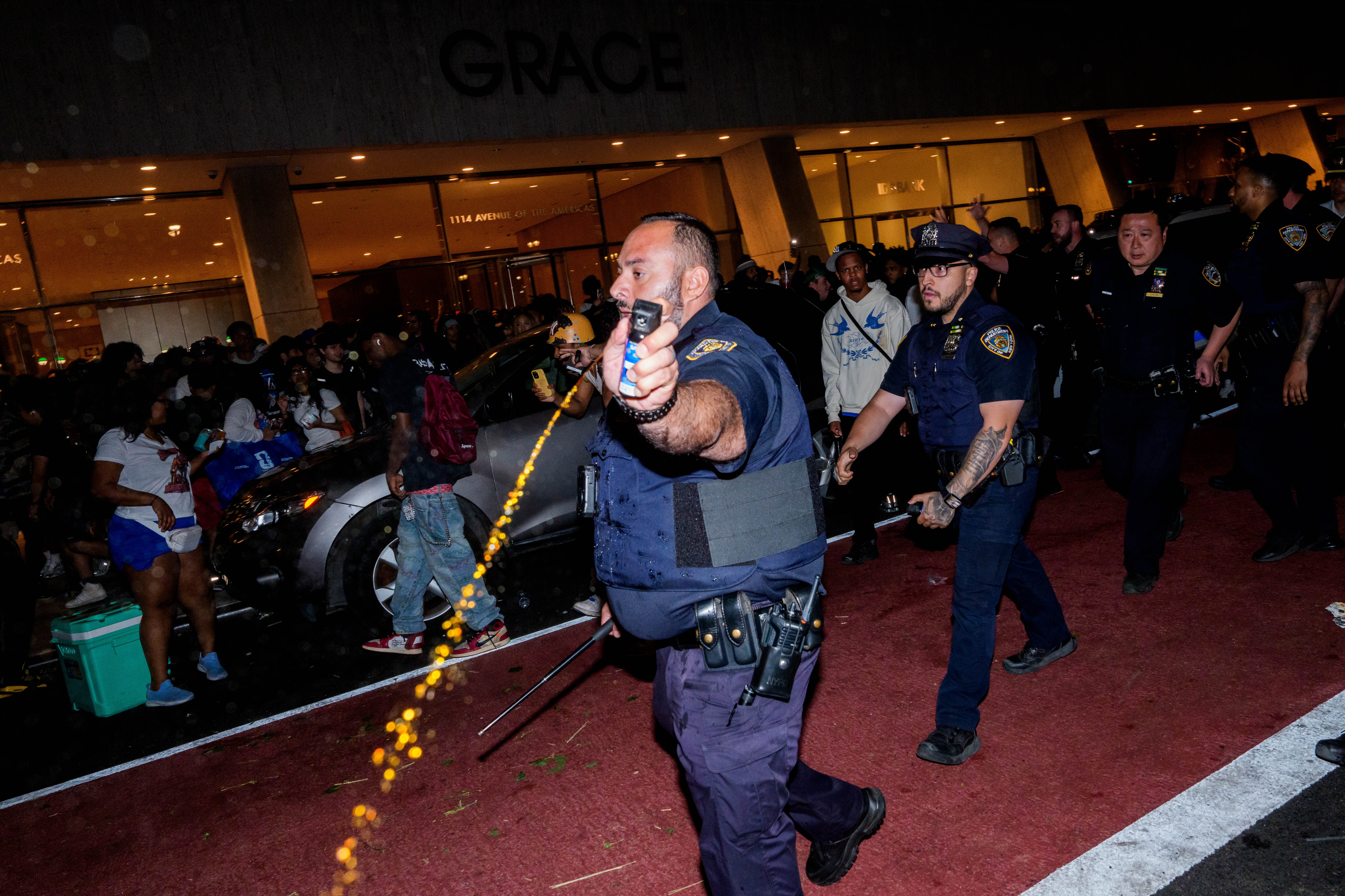 Policajac njujorške policije koristi biber sprej dok se navijači New York Knicksa sukobljavaju s policajcima