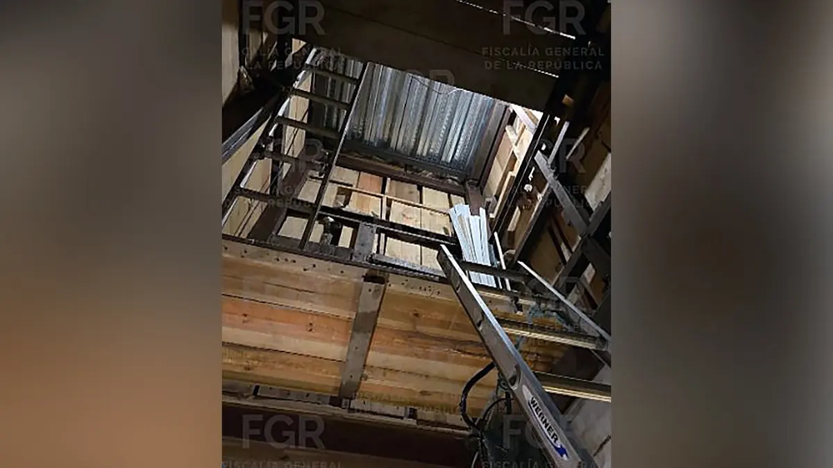 Pogled gleda prema gore kroz okomito okno s ljestvama koje vode do površine iznad.