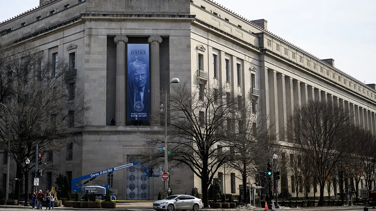 Transparent s likom američkog predsjednika Donalda Trumpa prikazan na pročelju zgrade američkog Ministarstva pravosuđa u Washingtonu, DC