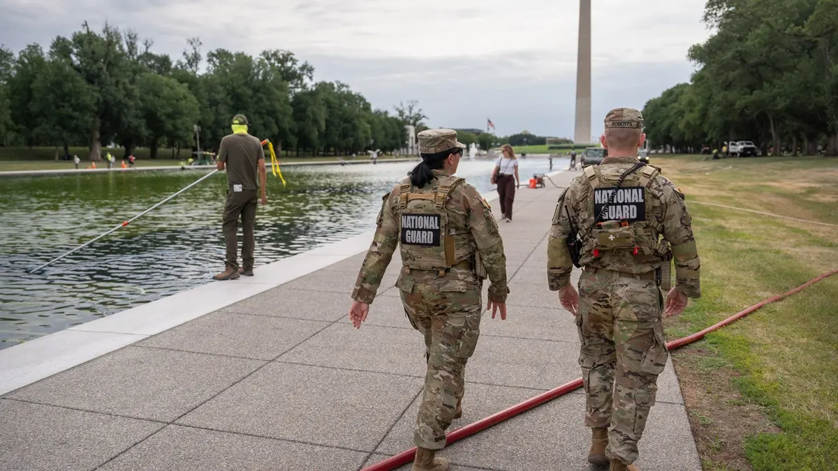 Pripadnici Nacionalne garde prolaze pored zaposlenika Službe nacionalnog parka koji usisavačem čisti Lincoln Memorial Reflecting Pool, petak, 19. lipnja 2026., u Washingtonu.