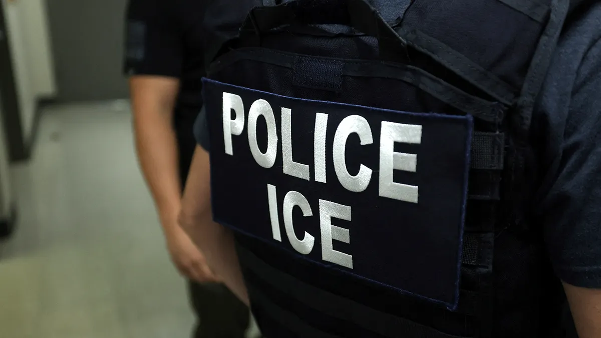 FILE - ICE agent stoji u hodniku ispred sudnice imigracijskog suda New York Federal Plaza