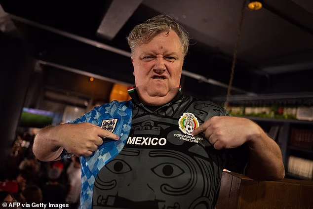 Jedan engleski navijač nosi nogometni dres pola Engleske, pola Meksika u baru u Mexico Cityju
