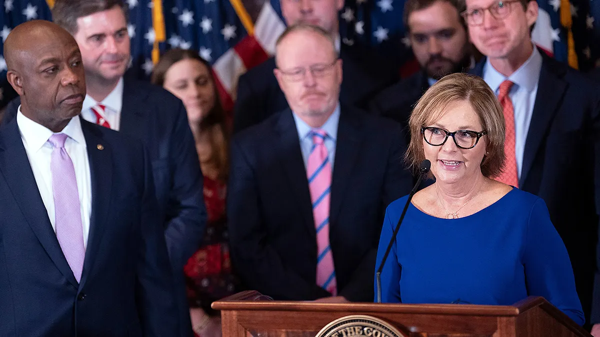 Novoimenovana privremena američka senatorica Darline Graham Nordone, desno, sa senatorom Timom Scottom, RS.C., lijevo, govori tijekom konferencije za novinare najavljujući njezino imenovanje da popuni upražnjeno mjesto koje je nastalo nakon smrti njenog brata, američkog senatora Lindseyja Grahama, u državnoj kući u ponedjeljak, 13. srpnja 2026., u Columbiji, SC (AP Photo/Sean Rayford)