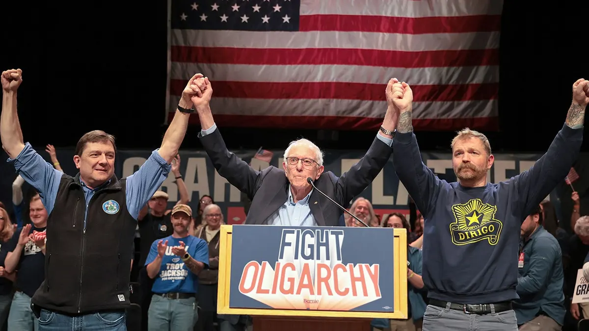 Bernie Sanders stoji s Troyem Jacksonom i Grahamom Platnerom na pozornici.
