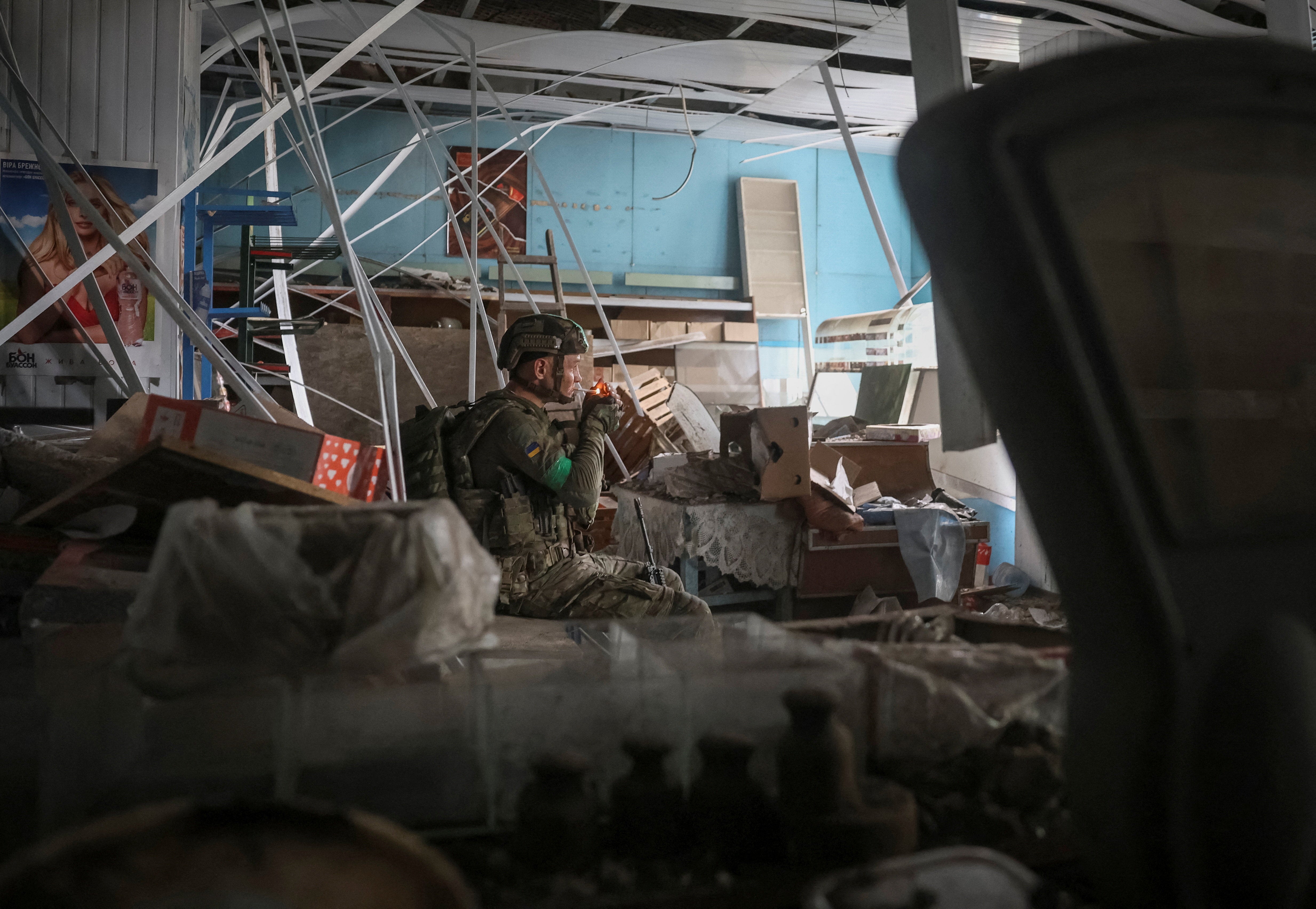 Ukrajinski vojnik počiva unutar oštećene trgovine tijekom svoje borbene misije u gradu Družkivki na prvoj liniji, u regiji Donjecka, 9. srpnja