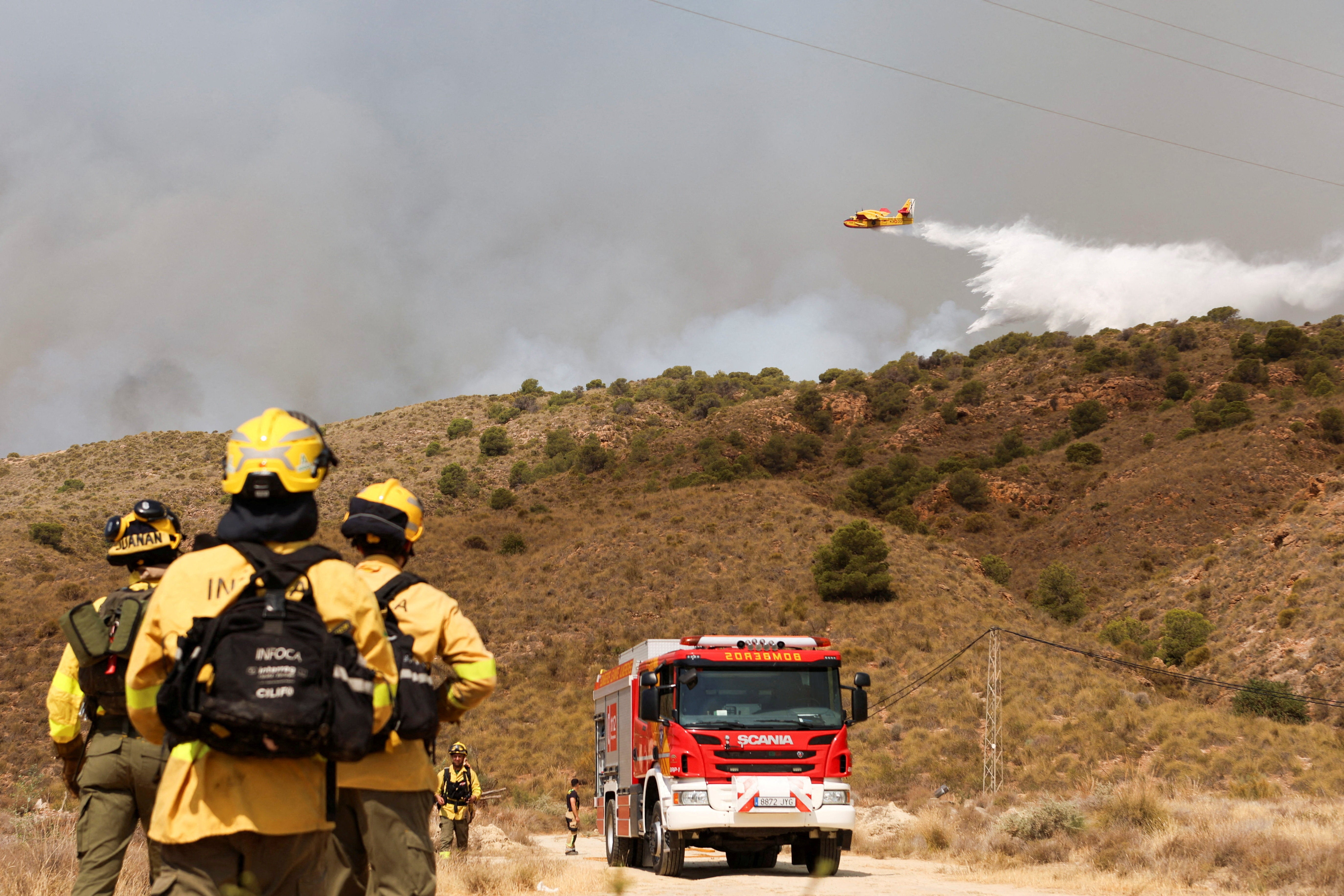 Vatrogasci promatraju kako se voda baca preko požara u Los Gallardosu, Almeria, Španjolska