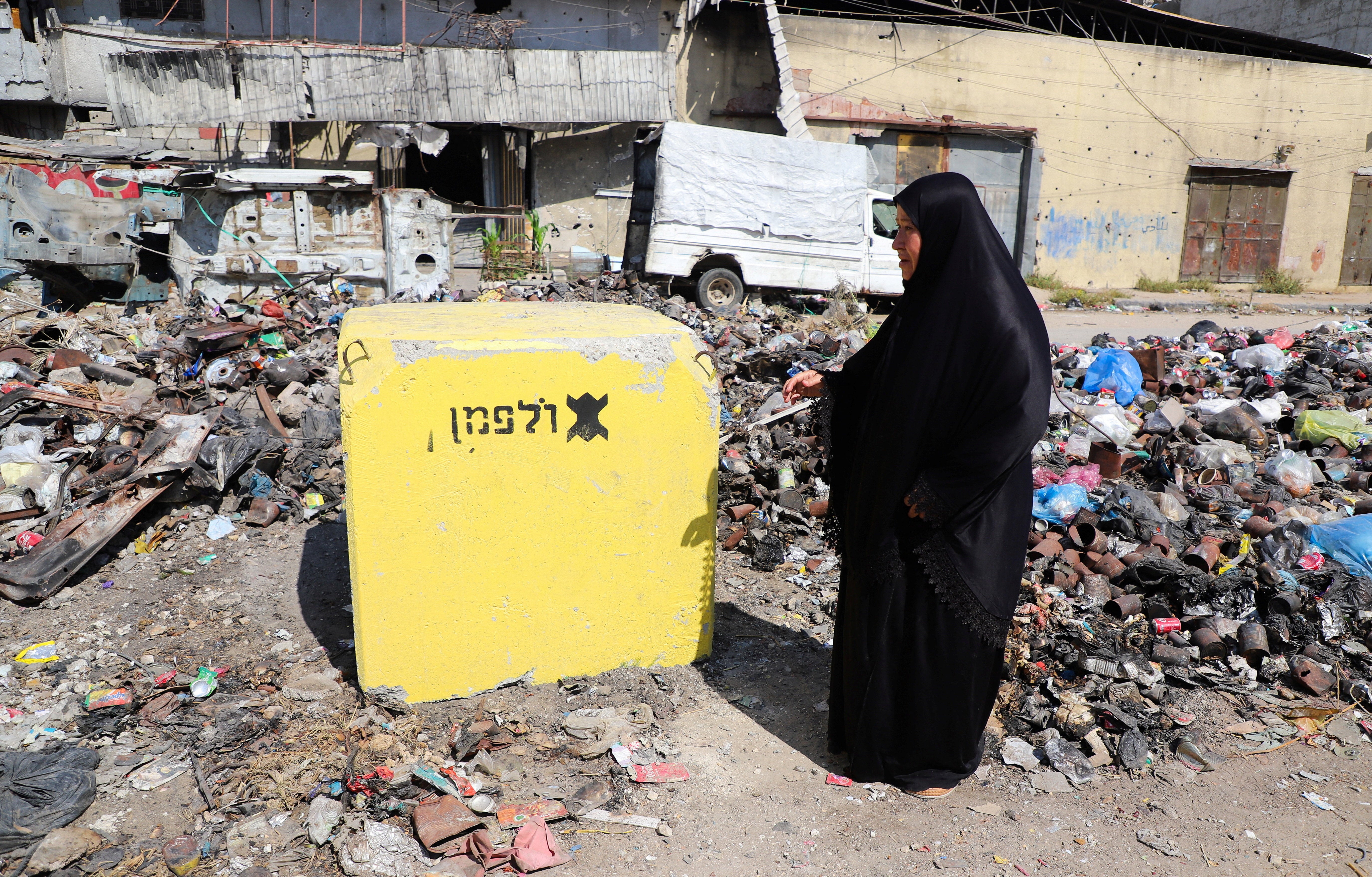 Palestinka gleda u žuti betonski blok koji označava 'žutu zonu' pod kontrolom izraelske vojske, u četvrti Tufah, u gradu Gazi, 27. srpnja 2026. REUTERS/Ebrahim Hajjaj