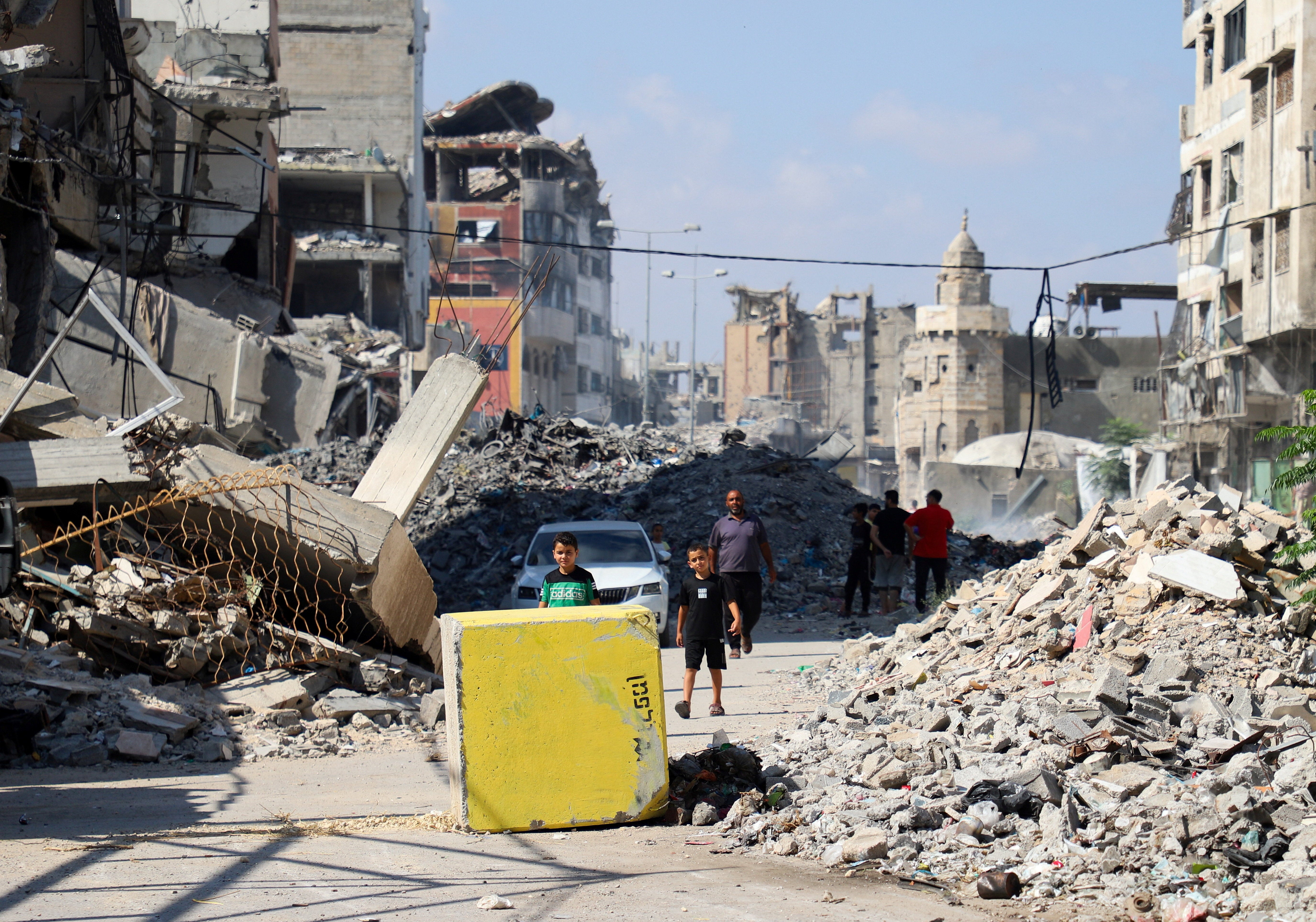Palestinci gledaju prema žutom betonskom bloku koji označava 'žutu zonu' pod kontrolom izraelske vojske, u četvrti Tufah, u gradu Gazi, 27. srpnja 2026.