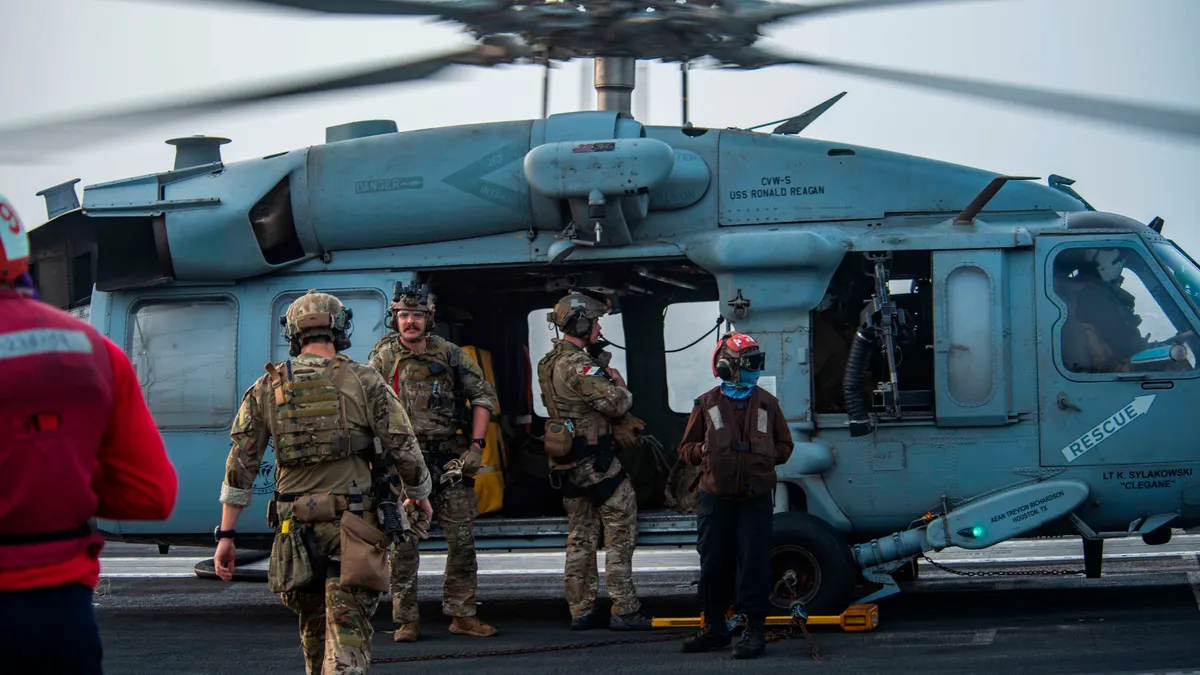 DATOTEKA - Na ovoj fotografiji koju je dostavila američka mornarica, mornari dodijeljeni jedinici za eksplozivna sredstva ukrcavaju se u helikopter MH-60S Seahawk na pilotskoj palubi nosača zrakoplova USS Ronald Reagan kako bi krenuli prema naftnom tankeru koji je napadnut u blizini obale Omana u Arapskom moru u petak, 30. srpnja 2021.