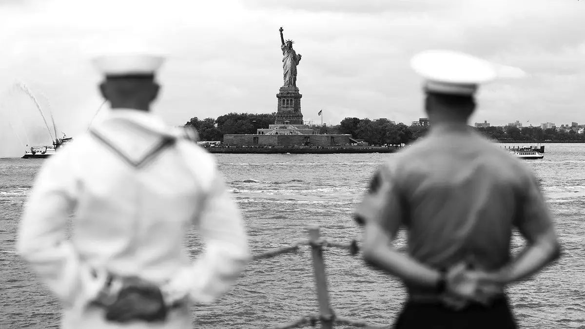 Crno-bijela fotografija dvojice američkih vojnika okrenutih prema Kipu slobode koju je izradila fotografkinja Korina Marie Moore.