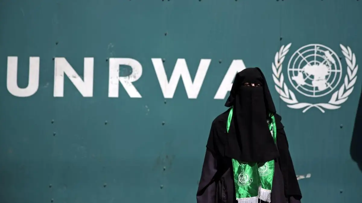 Palestinka nosi zeleni Hamasov šal na prosvjedu protiv nedostatka sredstava UN-ove Agencije za pomoć i rad (UNRWA) zbog kojeg bi oko 500 000 palestinskih učenika ove jeseni moglo ostati izvan škole, ispred sjedišta UNRWA-e u Gazi u gradu Gazi, nedjelja, 16. kolovoza 2015. Zamjenica šefa UNRWA-e, koja upravlja sa 700 škola, Sandra Mitchell je to rekao "ako sredstva ne stignu" ovog mjeseca bi agencija mogla odgoditi početak školske godine. (AP Photo/Khalil Hamra)