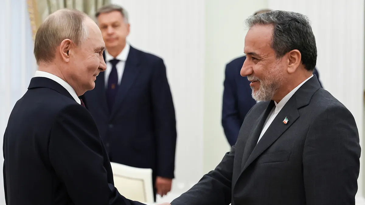 Russian President Vladimir Putin greets Iranian Foreign Minister Abbas Araghchi