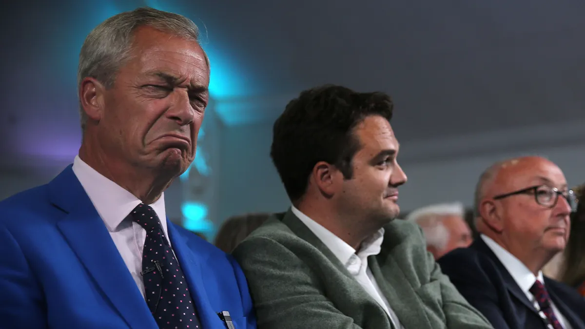 Vođa reforme Nigel Farage i kandidat za povjerenika policije Norfolka i kriminala Colin Sutton (treći lijevo) slušaju i reagiraju na govore u Holiday Innu 29. lipnja 2026. u Norwichu, Engleska. Dopunski izbori za odabir sljedećeg povjerenika policije Norfolka i kriminala (PCC) održat će se u četvrtak, 16. srpnja 2026. Izbore je pokrenula ostavka bivše PCC Sarah Taylor zbog ozbiljne bolesti u njezinoj obitelji. Dopunski izbori potaknuli su značajnu raspravu, budući da nosi procijenjeni trošak poreznih obveznika od 2 milijuna funti za ulogu koja bi trebala biti ukinuta 2028. kada regionalni planovi decentralizacije uvedu izravno izabranog gradonačelnika za Norfolk i Suffolk.