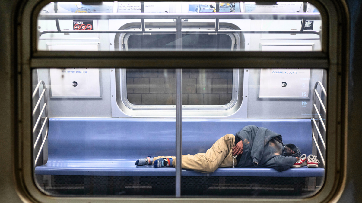 Čovjek je viđen kako spava u vlaku E, jednoj od linija podzemne željeznice koju beskućnici iz New Yorka najviše koriste za utočište u ponedjeljak, 7. travnja 2025.