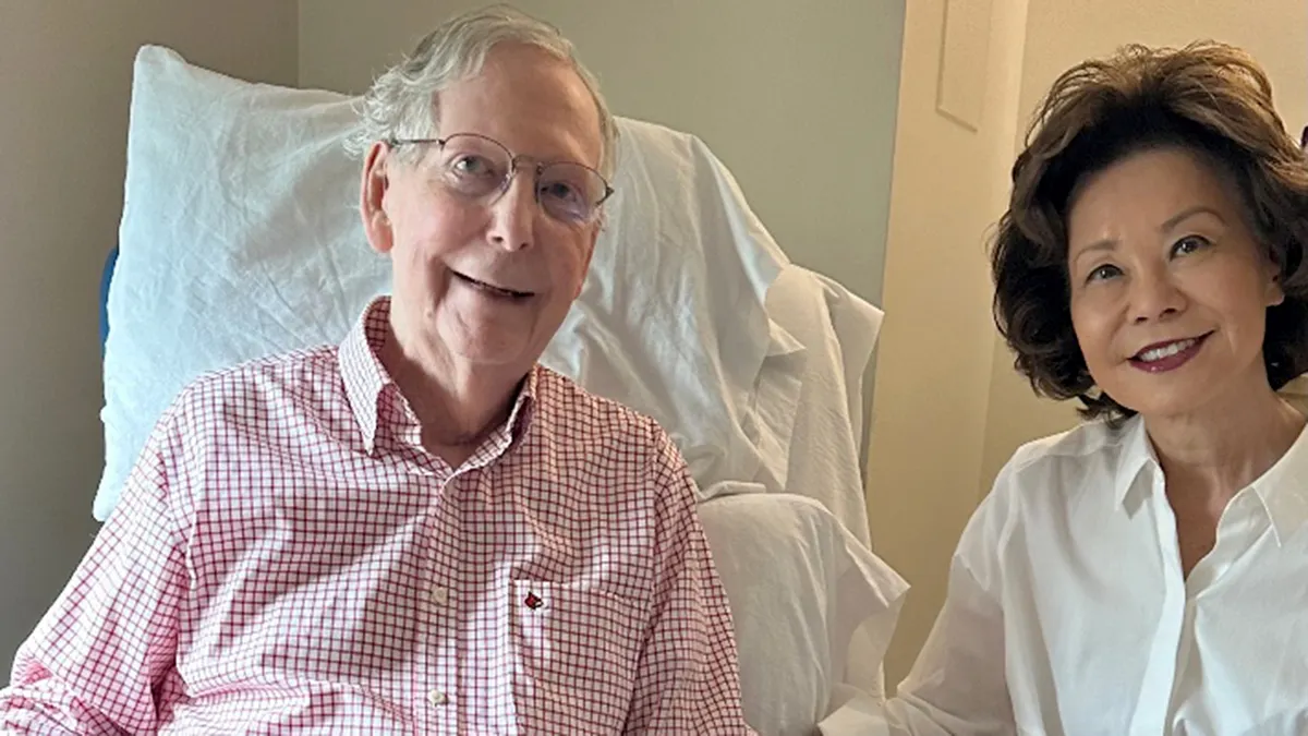 Mitch McConnell sjedi s bolničke stolice pokraj svoje žene.