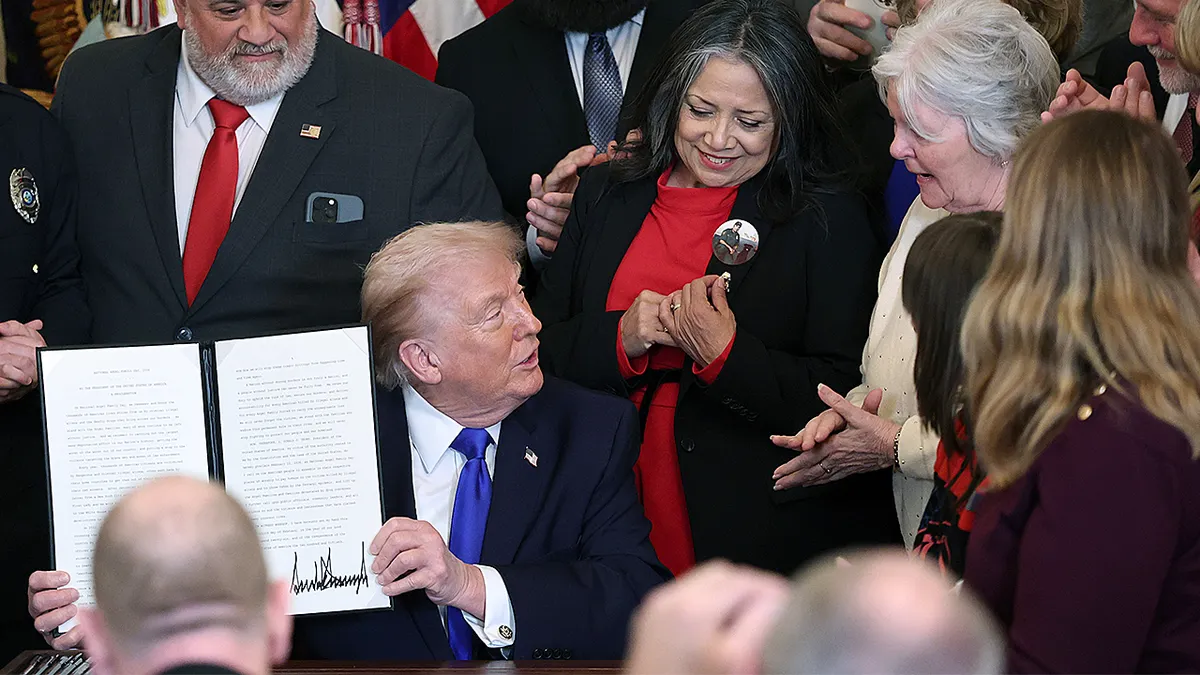Donald Trump drži potpisani proglas dok stoji u istočnoj sobi Bijele kuće.