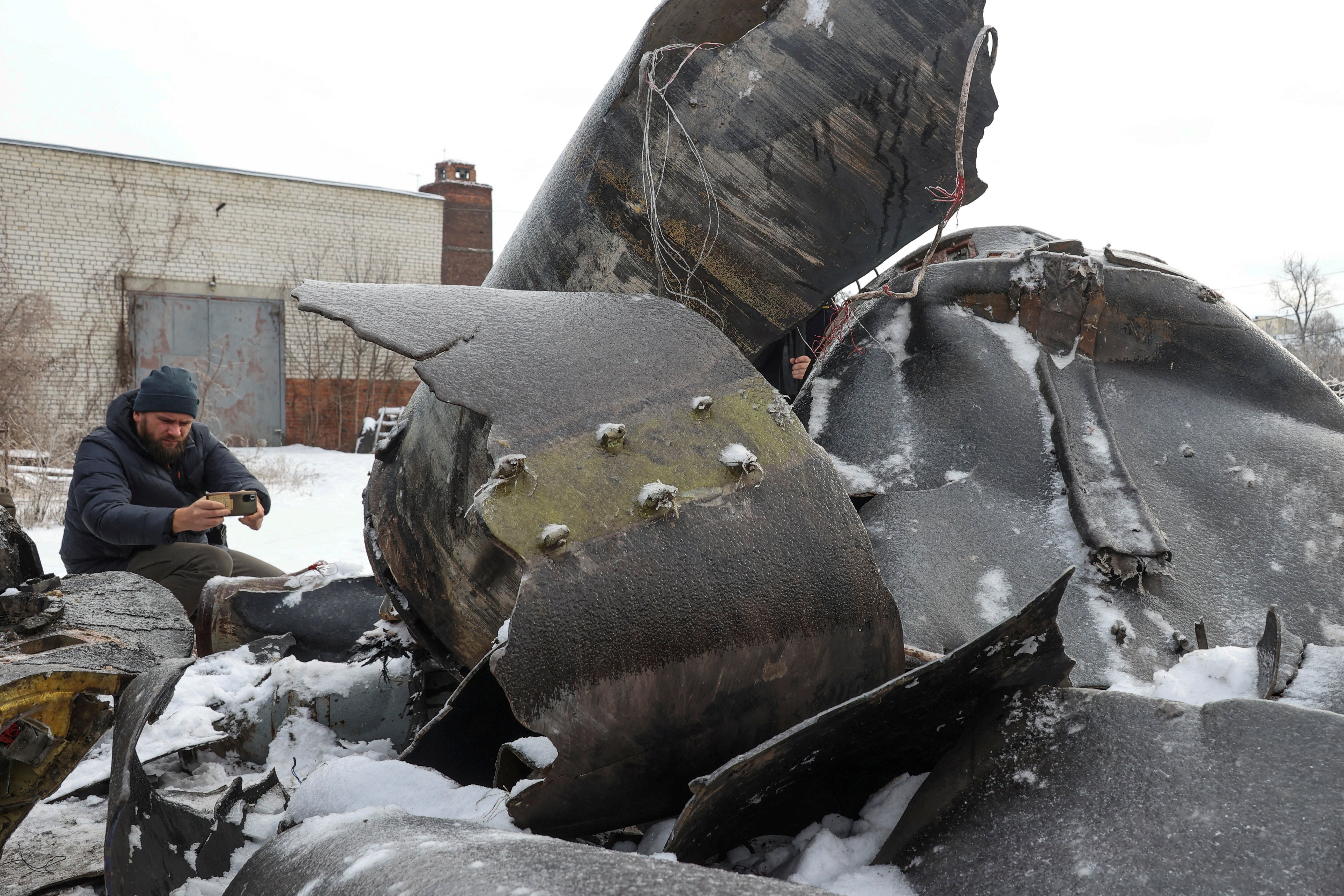 FILE PHOTO: A man photographs parts of an unidentified missile, which Ukrainian authorities believe to be made in North Korea and was used in a strike in Kharkiv earlier this week, amid Russia's attack on Ukraine, in Kharkiv, Ukraine January 6, 2024
