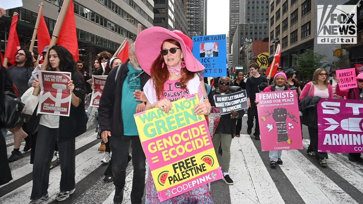 Jodie Evans marches alongside Revolutionary Communists of America protesters carrying red flags during an anti-Israel demonstration in New York City.