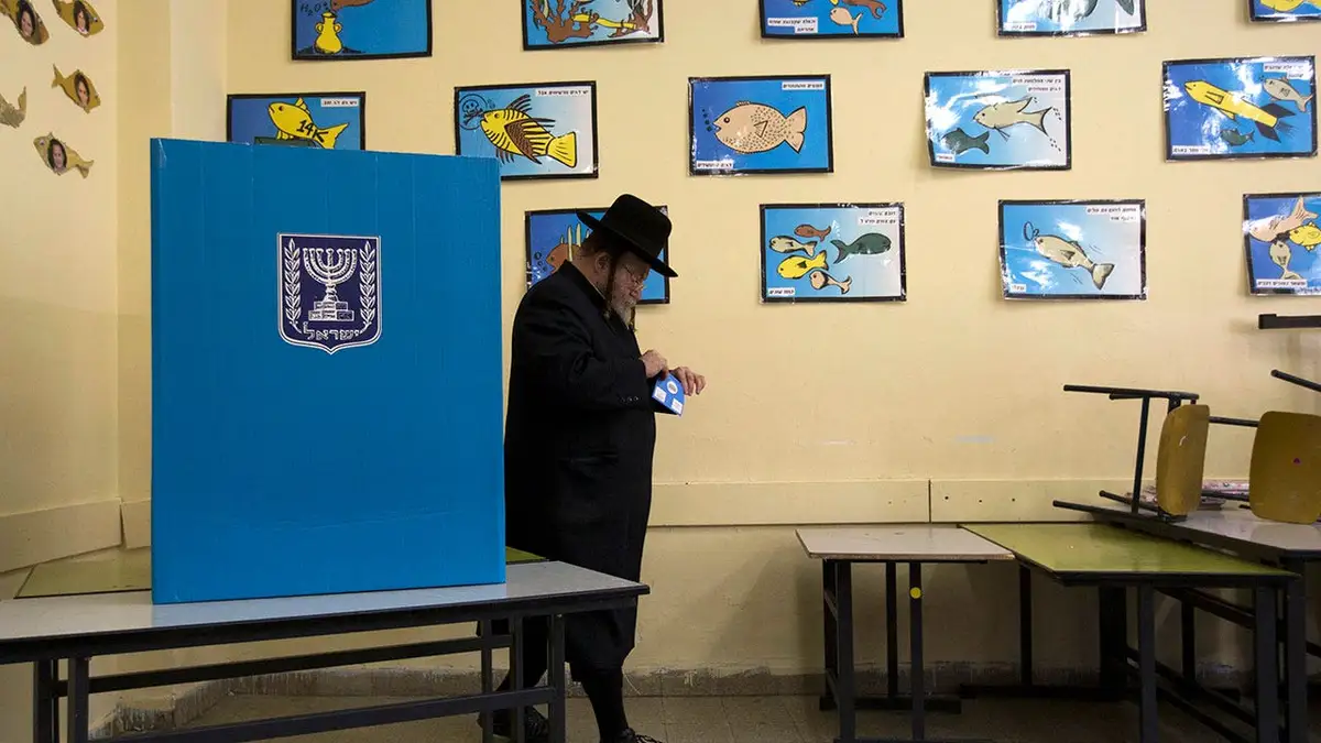 An ultra-Orthodox Jewish man holds his ballot as he votes in the parliamentary election at a polling station in Jerusalem