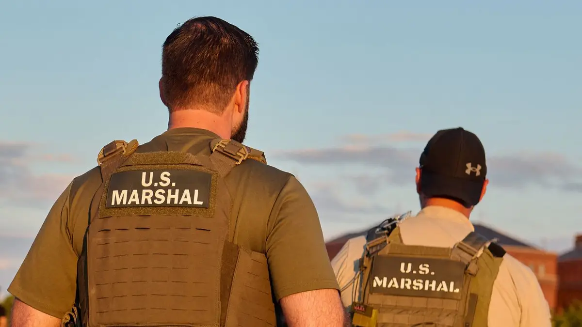 Agenti američkih maršala u taktičkim prslucima šetaju javnim parkom.